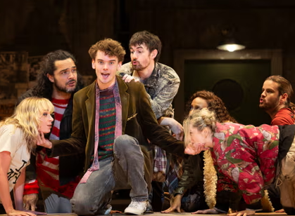 Noah Mullins and the cast of Rent performing on stage in Melbourne